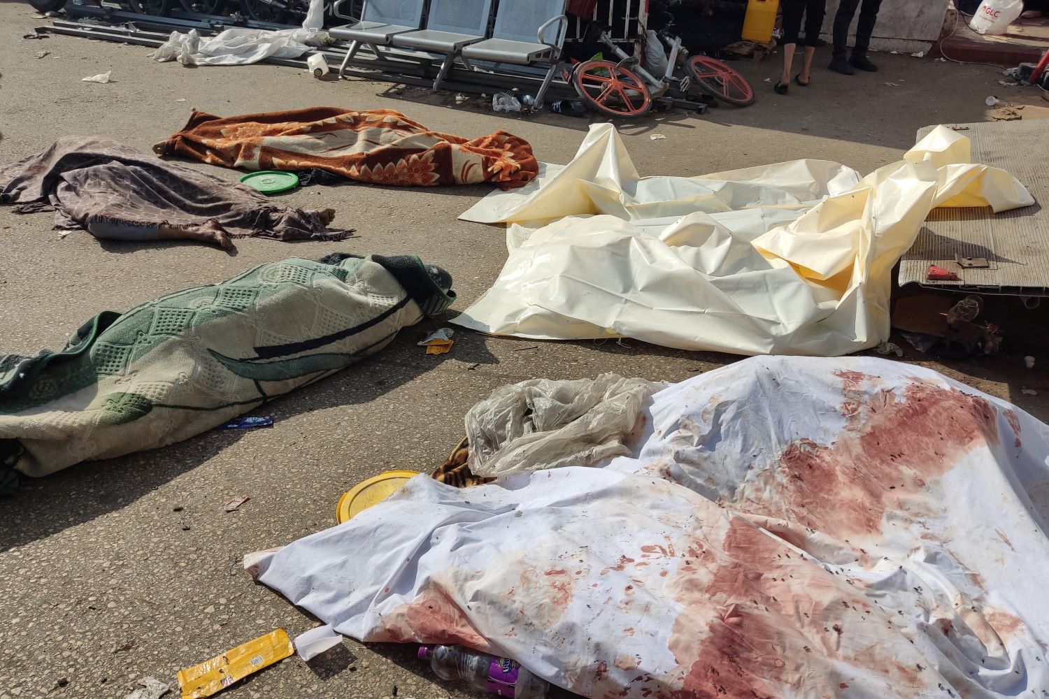 جثامين شهداء ارتقوا في غارة لطائرات الاحتلال ملقاة على الأرض قرب مجمع الشفاء (تصوير ا ف ب)